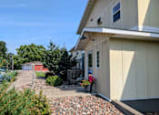 Thumbnail 3 of 9 - A house with a red shed in the background.