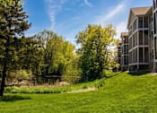 Thumbnail 4 of 59 - A serene landscape with a building on the right and trees in the background.
