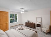 Thumbnail 36 of 59 - A bedroom with a bed, dresser, mirror, and chair.