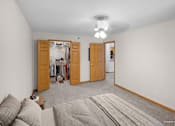 Thumbnail 38 of 59 - A bedroom with a grey carpet and two open doors.
