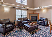Thumbnail 21 of 59 - A living room with a fireplace and leather chairs.