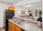 Thumbnail 46 of 59 - A kitchen with a black refrigerator and a marble countertop.