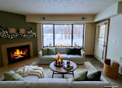 Thumbnail 40 of 59 - A cozy living room with a fireplace and a view of a snowy landscape outside.
