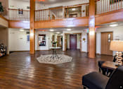 Thumbnail 22 of 59 - A large open space with a table and chairs in the foreground and a balcony in the background.