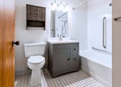 Thumbnail 33 of 59 - A white toilet sits next to a sink in a small bathroom.