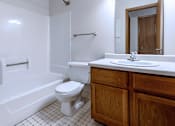 Thumbnail 30 of 59 - A white toilet sits in a bathroom next to a white sink.