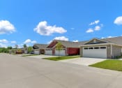 Thumbnail 9 of 11 - a house with a driveway and two garage doors