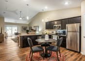 Thumbnail 11 of 11 - a kitchen and dining area with stainless steel appliances and a table