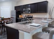 Thumbnail 4 of 9 - a kitchen with granite counter tops and a large island with a sink