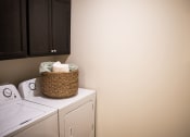 Thumbnail 8 of 9 - a laundry room with a washer and dryer and a basket on the top