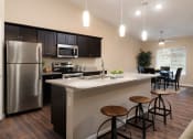 Thumbnail 4 of 10 - a kitchen with a large counter and a stainless steel refrigerator