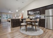 Thumbnail 4 of 10 - an open kitchen and dining room with stainless steel appliances and a table and chairs