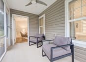 Thumbnail 10 of 10 - a covered porch with two chairs and a ceiling fan