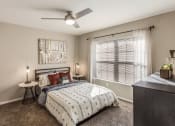 Thumbnail 4 of 8 - a bedroom with a bed and a ceiling fan