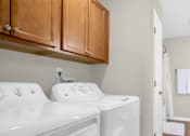 Thumbnail 8 of 15 - A washer and dryer in a laundry room.