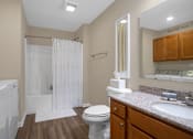 Thumbnail 11 of 15 - A bathroom with a toilet, sink, and shower.