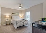 Thumbnail 14 of 15 - A bedroom with a bed, nightstands, and a ceiling fan.
