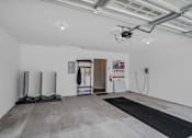 Thumbnail 4 of 15 - A room with a black mat on the floor and a white wall with a doorway leading to another room.