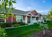 Thumbnail 3 of 20 - A red house with a white picket fence and a small tree in front.
