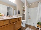 Thumbnail 16 of 21 - A bathroom with a toilet, sink, and shower.