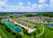 Thumbnail 10 of 21 - A bird's eye view of a residential area with houses and two lakes.