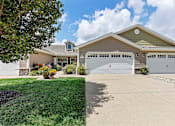 Thumbnail 1 of 21 - A house with a garage and a tree in front.