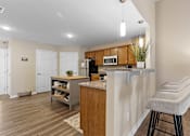 Thumbnail 6 of 21 - A kitchen with a bar stool in front of it.
