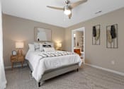 Thumbnail 20 of 21 - A bedroom with a large bed and a ceiling fan.