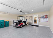 Thumbnail 7 of 21 - A room with a golf cart and a door with a sign on it.