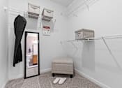 Thumbnail 9 of 21 - A white closet with a mirror, a bench, and a pair of slippers.