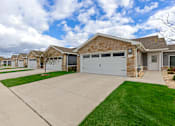 Thumbnail 4 of 23 - A row of houses with garages and driveways.