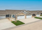 Thumbnail 1 of 23 - A house with a grey roof and a white garage door.