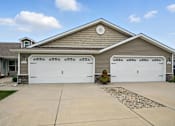 Thumbnail 1 of 15 - A house with two garages and a driveway.
