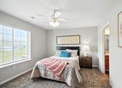 Thumbnail 10 of 15 - A bedroom with a bed, a ceiling fan, and a window with blinds.