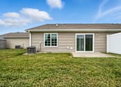 Thumbnail 3 of 15 - A house with a brown roof and a grey siding with a white fence in front.
