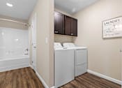 Thumbnail 14 of 20 - A laundry sign is on the wall above a washer and dryer.
