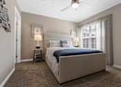 Thumbnail 7 of 20 - A bedroom with a large bed and a ceiling fan.
