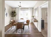 Thumbnail 10 of 18 - A dining room with a round table and chairs.