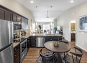 Thumbnail 6 of 18 - A modern kitchen with dark wood cabinets and stainless steel appliances.