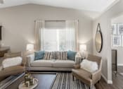 Thumbnail 9 of 18 - A living room with a grey couch and a coffee table.