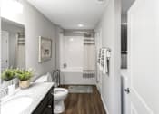 Thumbnail 15 of 18 - A white bathroom with a toilet, sink, and bathtub.