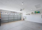 Thumbnail 18 of 18 - A garage with a grey door and a white wall.