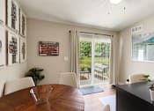 Thumbnail 10 of 16 - A dining room with a wooden table and chairs.