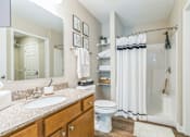 Thumbnail 14 of 16 - A bathroom with a white toilet, sink, and shower.