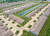 Thumbnail 3 of 16 - A bird's eye view of a residential neighborhood with houses and a swimming pool.