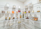 Thumbnail 7 of 16 - A white pantry with shelves full of food and drinks.