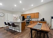 Thumbnail 5 of 16 - A kitchen with a table and chairs in the middle of the room.