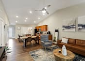 Thumbnail 8 of 16 - A living room with a brown leather couch and a wooden coffee table.