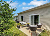 Thumbnail 2 of 16 - A patio with a table and chairs is in front of a house.