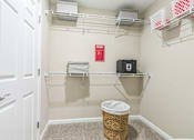 Thumbnail 13 of 16 - A white door is open to a small closet with a basket on the floor.